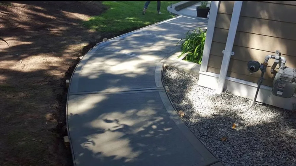 Curved concrete side path with borders past a gas meter