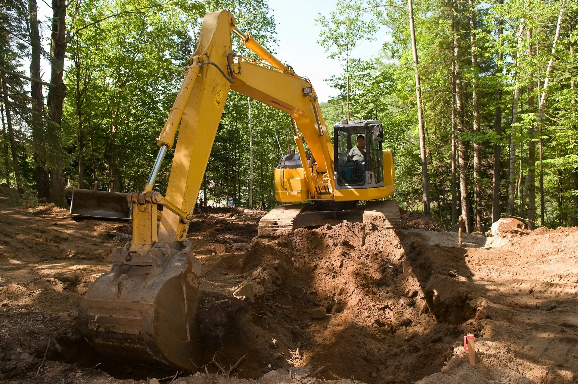 Excavator digging and grading a site for new construction