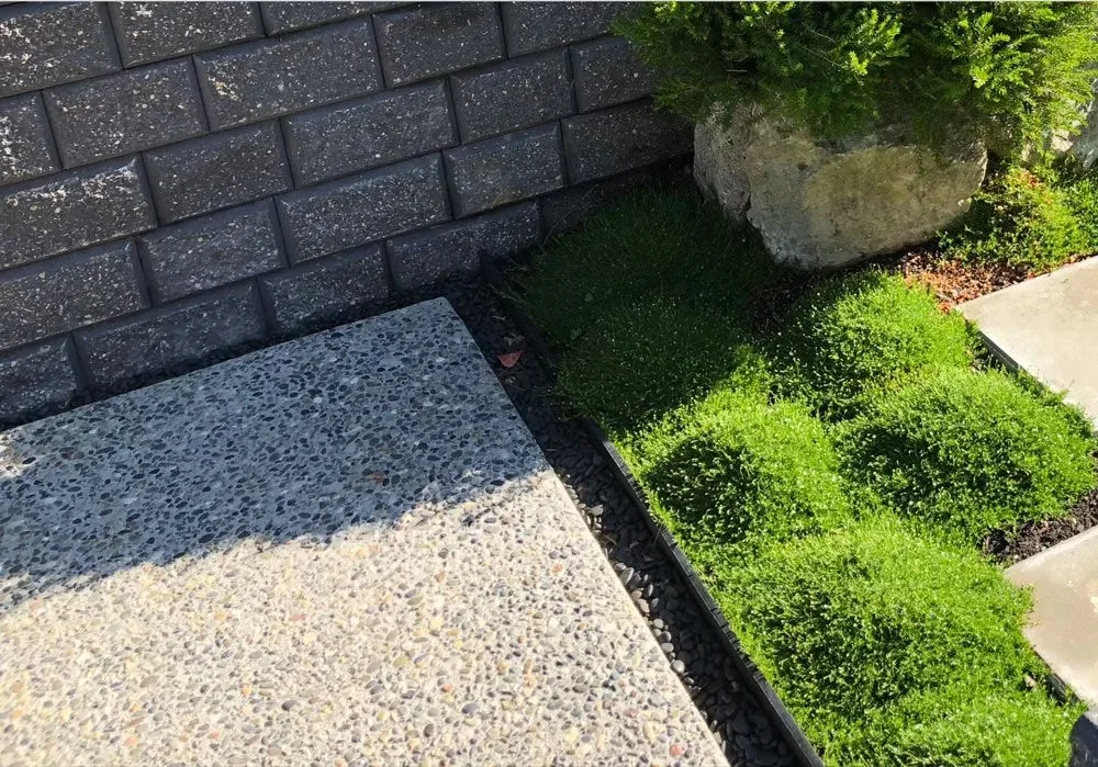 Exposed aggregate slab beside a block retaining wall