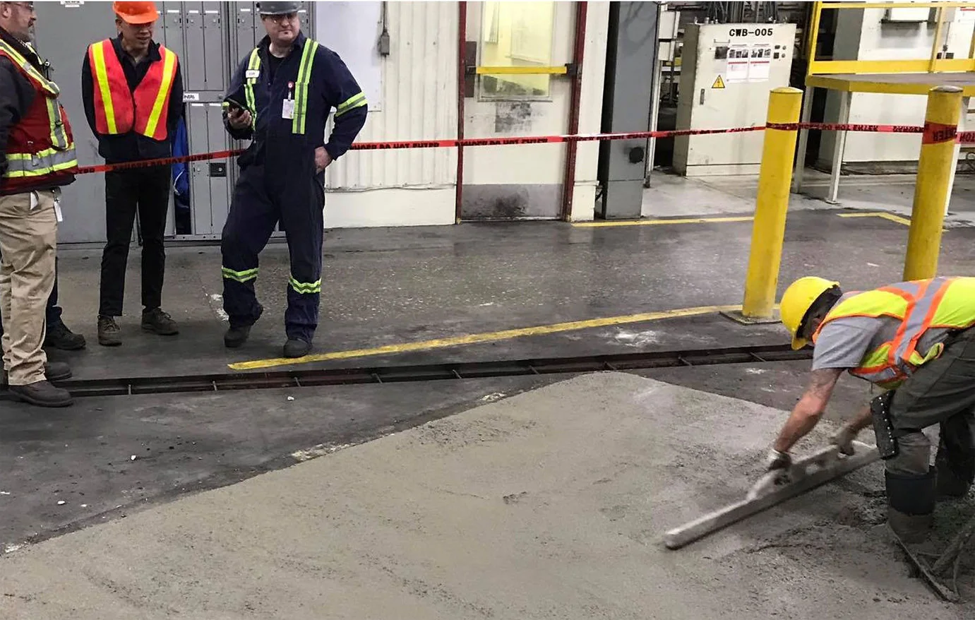 Finisher screeding a concrete trench repair inside an industrial facility