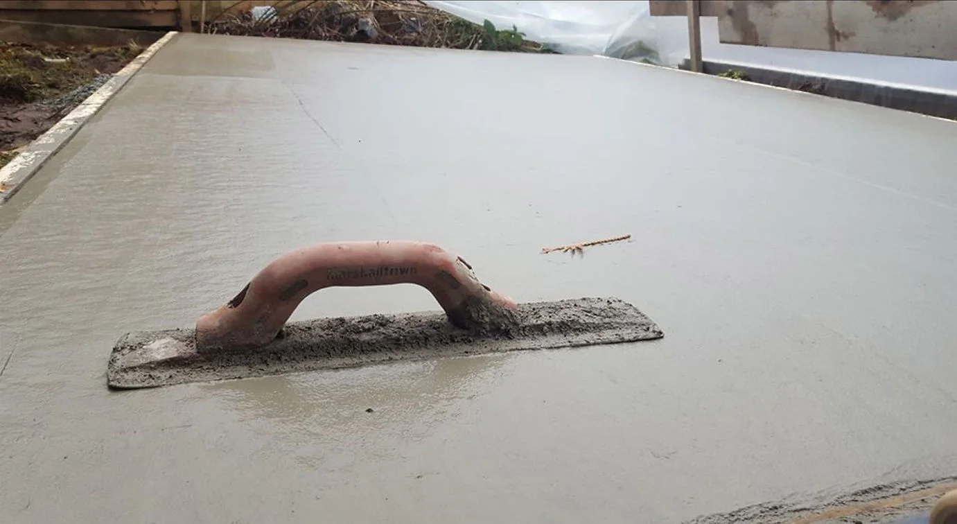 Hand float resting on freshly placed concrete